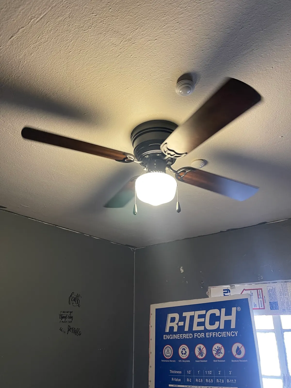 Ceiling fan with light kit installed and running in a bedroom