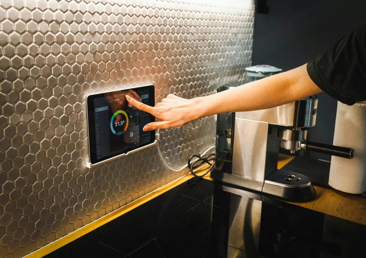 Homeowner using a wall-mounted smart home control panel